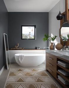 a bathroom with a bathtub, sink and large mirror in the corner on the wall