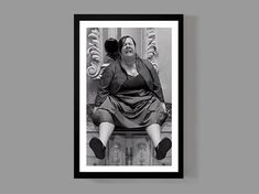 a black and white photo of a woman sitting on a bench