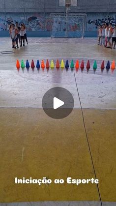 a group of people standing around in an indoor area with colored cones on the floor