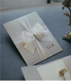 a white wedding card with a bow on the front, and an envelope that says ga