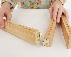 a person is holding two wooden pegs on the table