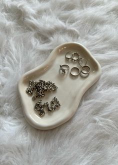 a white tray with rings on it sitting on a furnishing area next to a pair of scissors