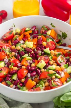 a white bowl filled with salad next to orange juice