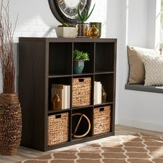 a room with a window and a clock on the wall next to a shelf filled with books