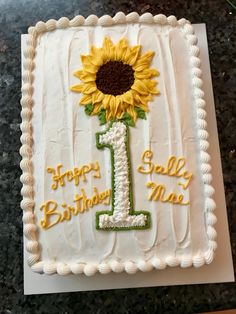 a birthday cake decorated with a sunflower and the number 1 on it's side