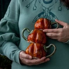 a woman is holding three peppers in her hands