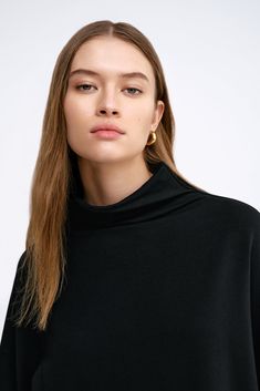 Make yourself at home in our Amanda Sweatshirt, an elegantly oversized silhouette made for living in anywhere, anytime. She envelops you in softness and warmth with our lightweight, breathable European French Terry. Featuring dropped shoulders that extend to beautifully wide long sleeves and a high collar, Amanda is cool, comfortable and endlessly versatile. | Bianca, in black, is 5'8.5" (174 cm) tall, wearing size XS. Astrid, in mist and in off white, is 5'9" (175 cm) tall, wearing size XS. Tot Boxy Fit Tops For Fall, Oversized Funnel Neck Top For Loungewear, Oversized Funnel Neck Solid Top, Oversized Solid Funnel Neck Top, Solid Color Oversized Top With Funnel Neck, Oversized Black Funnel Neck Tops, Oversized Black Tops With Funnel Neck, Relaxed Fit High Neck Tops, Oversized Funnel Neck Top For Fall