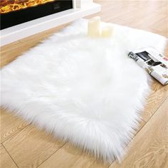 a white area rug sitting on top of a wooden floor next to a fire place