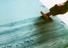 a person is using a sanding tool on a piece of wood that has been stained blue