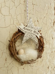 a star ornament hanging on the side of a wall next to a bird nest