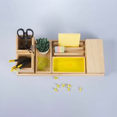 a wooden desk organizer with office supplies on it, including scissors and other office supplies