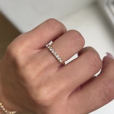 a woman's hand with a diamond ring on top of her left hand,