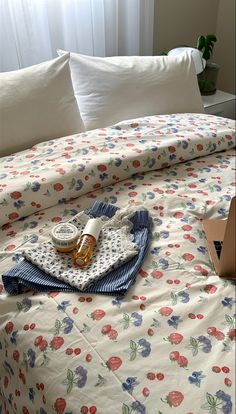 an unmade bed with white sheets and flowers on it