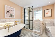 a bathroom with a claw foot tub and tiled walls, along with a walk in shower