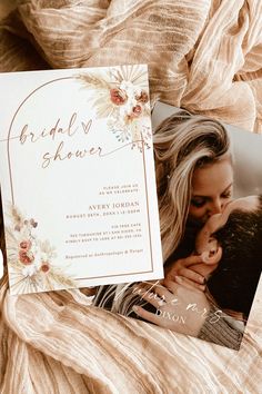 an image of a woman kissing her man on the cheek with flowers around them and a wedding shower card