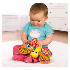 a baby sitting on the floor playing with a toy