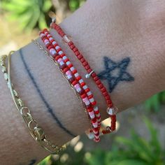 dark frosted red, matter red, pink and luster white seed bead bracelet strung on elastic please gently roll on and off to prolong its life handmade in venice, ca Casual Red Friendship Bracelets With Round Beads, Beach Red Friendship Bracelets With Colorful Beads, Casual Red Round Beads Friendship Bracelets, Red Friendship Bracelets With Colorful Beads, Red Adjustable Beaded Necklaces With Spacer Beads, Red Braided Friendship Bracelets, Casual Red Round Beads Friendship Bracelet, Red Beaded Bracelets With Heart Beads For Friendship, Adjustable Red Friendship Bracelets With Colorful Beads