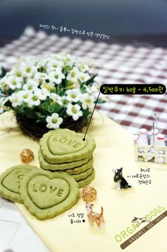 some cookies are sitting on a table with flowers in the middle and small figurines next to them