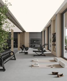 an indoor gym area with exercise equipment and yoga mats on the floor next to large windows