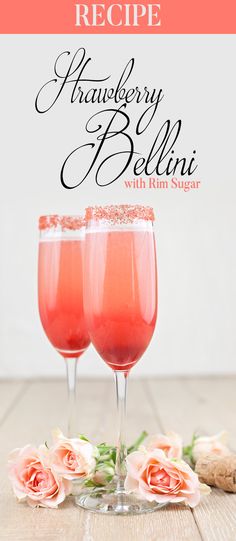 two glasses filled with pink liquid on top of a wooden table next to some flowers