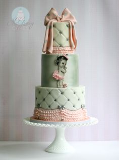 a three tiered cake with an image of a woman on the side and pink bows