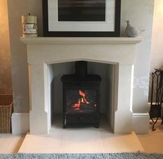 a fire place in a living room with a painting on the wall and carpeted floor