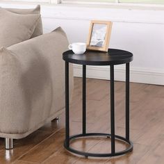 a small table with a cup on it next to a couch