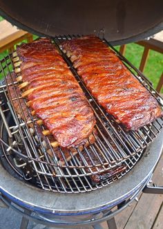 two steaks cooking on top of a bbq grill