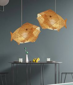 two gold fish lamps hanging over a table