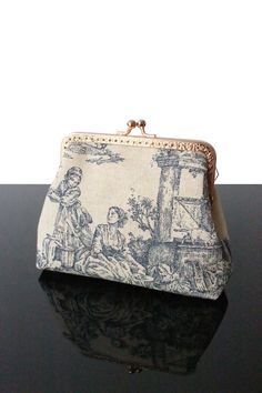 "You search a small original present for your familie  (child, mom, granny, sister)? Here is our collection of Toile de jouy cosmetic  bag with  kisslock frame for women - trend for 2024.  Can also be used as a small cosmetic bag or makeup bag not taking up much space in your handbag, or as a small storage kit. And why, not just as an object of decoration. Some Toile de jouy makeup bag are can also used as a small pouch. You will enjoy quality materials (Linen fabric, Toile de jouy, tweed fabric, French tapestry, wool fabric, velvet corduroy, Japanese cotton). Handmade bag with 100% linen fabric.  * 100% Toile de jouy * Inside 100% coton/linen fabric    * Interfacing  for structure Height 5,1\" Length  5,9\" Depth  1,6\" Frame kiss lock Golden hardware 4,9\" Only 1 in stock! Made in France Vintage Cosmetic Bag, Vintage Makeup Bag, Vintage Bag Pattern, Navy Blue Clutch, Small Cosmetic Bag, My Style Bags, Luxury Bags Collection, Blue Clutch, Small Makeup Bag