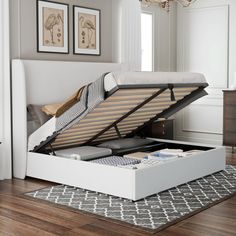 a bed with a mattress in it on top of a wooden floor next to a rug