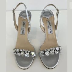 Jimmy Choo Lotus Silver Leather Crystal Sandals Size Eu 37.5 / Us 7.5 Brand: Jimmy Choo London Material: Nappa Leather & Crystals Color: Silver Approximate Heel Height: 4-4.25” Size: Eu 37.5 / Us 7.5 Made In Italy Condition: Very Good, Put Them On In The House For About An Hour, Faint Light Wear On Soles, Right Heel Slight Mark In Photo, When Held Up To View, I Don't See It, Near Heel Rests, Tiny Marks & Some Silver On Heel Will Need Touched Up. Jimmy Choo Crystal Heels, Jimmy Choo Sparkly Heels, Jimmy Choo Glitter Heels, Jimmy Choo Metallic Heels, Grey Jimmy Choo Heels, Crystal Sandals, Hold Ups, Jimmy Choo Shoes, Touch Up