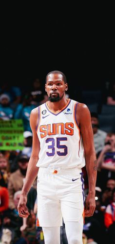 a basketball player standing on the court with his hands in his pockets and looking down