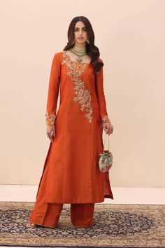 Traditional Orange Pakistani Salwar Kameez Dupatta Suit is magnified by an array of vibrant precious stones, each one catching the light in a dance of color. Orange Salwar Kameez, Transitional Anarkali Palazzo Set With Floral Embroidery, Embroidered Raw Silk Palazzo Set For Reception, Anarkali Embroidered Tissue Silk Palazzo Set, Elegant Churidar With Floral Embroidery In Chanderi, Art Silk Sharara With Floral Embroidery And Straight Kurta, Elegant Chanderi Churidar With Floral Embroidery, Elegant Churidar With Floral Embroidery And Traditional Drape, Designer Silk Sharara With Floral Embroidery