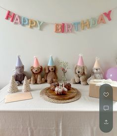 a birthday party with teddy bears, cake and bundts on a table in front of a sign that says happy birthday