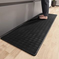 a person standing on a mat in the kitchen