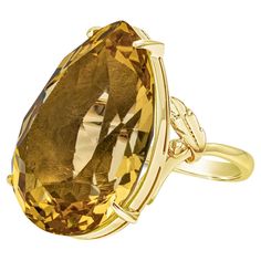 This color-rich cocktail ring features a pear shape golden citrine weighing 30.92 carats total, beautifully set in a four prong basket setting. Finely made in 18k yellow gold. Luxury Pear-shaped Gemstone Rings, Pear-shaped Yellow Gold Topaz Ring, Formal Yellow Gold Topaz Teardrop Ring, Formal Pear-shaped Citrine Ring, Gold Teardrop Topaz Ring For Formal Occasions, Formal Yellow Pear-shaped Ring, Elegant Yellow Gold Pear-shaped Topaz Ring, Elegant Pear-shaped Yellow Gold Topaz Ring, Pear-shaped Topaz Ring For Formal Occasions