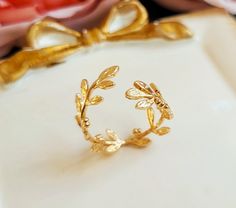 A lovely open Laurel wreath ring features small leaves wrap around your finger. Ring is adjustable to fit any size.  Ring is brass with gold plating. Enjoy! Purchase over $40 enjoys free shipping! Coupon code 'freeshipping1'. Free Gift Wrapping on request - All items that are gift wrapped come in with a kraft box with raffia string and blank writing card.  Please leave a note if you need it upon ordering. Laurel Ring, Laurel Wreath Ring, Gold Leaf Ring, Wreath Ring, College Rings, Ring Wreath, Wreath Rings, Gold Leaf Rings, Small Leaves