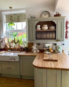 a kitchen filled with lots of counter top space and wooden flooring next to a window