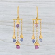 These earrings are a Marie Helene de Taillac design featuring elegant circle links with a bell like base accented by sparkling gemstone briolettes. Gem: Natural Amethyst - 5 x 3.2 mm, Briolette Cut, Purple Color - Natural Iolite - 5 x 3 mm, Briolette Cut, Blue Color - Natural Garnet - 5.5 x 4 mm, Briolette Cut, Red Color Metal: 18k and 22k Yellow Gold (XRF tested) Weight: 5.6 Grams Closure: Hook Posts Measurements: 49.8 x 11.8 mm Each piece is thoroughly examined and refinished as needed by our Formal Multi-stone Dangle Earrings, Modern Yellow Gold Multi-stone Earrings, Modern Multi-stone Yellow Gold Earrings, Fine Jewelry Multi-stone Dangle Earrings, Elegant Multi-stone Briolette Earrings, Mens Custom Jewelry, Briolette Earrings, Bell Earrings, Smoky Quartz Ring