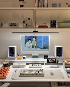 a desk with a computer and speakers on it