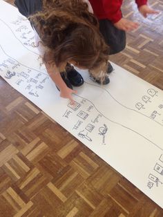 a young child is drawing on the floor