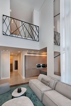 a living room filled with furniture next to a tall white wall and window sill