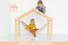 two children playing in a hammock made out of wood