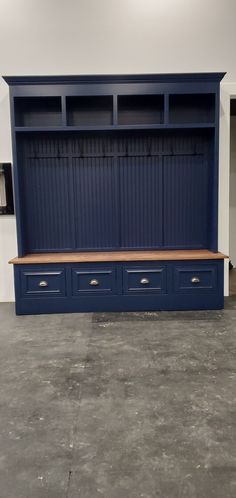 a blue bookcase with two drawers and a bench