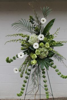 a white and green floral arrangement on a stand