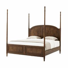 a bed with four posts and white sheets