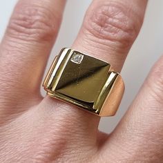 "A traditional signet ring with a rectangular face, set with single brilliant cut diamond, fully crafted in 9ct yellow gold and weighing a substantial 14.1 grams. Suitable for men or for women. Circa 1980's. Stamped \"18CT\". The face of the ring measures approximately 13.3mm from top to bottom. The approximate weight is 14.1 grams. Please note that the antique ring box pictured is for display purposes only. Thank you. Ring size S (UK) or 9 1/8 (US) - this ring can be adjusted in size in our workshop. Please get in touch to discuss sizing options and lead time. For UK to US ring size conversions we use www.ringsizes.co as our reference chart. CONDITION: In very good vintage condition, with some light surface wear commensurate with age. LAYAWAY: We happily offer layaway/deposits on the majo Classic Rectangular Signet Ring Stamped 14k, Modernist Rectangular Signet Ring With Polished Finish, Modernist Rectangular Signet Ring For Anniversary, Formal Rectangular Signet Ring With Polished Finish, Rectangular Modernist Signet Ring With Polished Finish, Classic Rectangular Signet Ring For Formal Occasions, Gold Rectangular Ring With Single Diamond, Rectangular Gold Ring With Single Diamond, Vintage Gold Signet Ring With Single Diamond