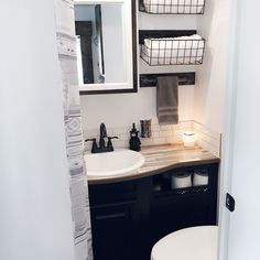 a bathroom with a sink, mirror and toilet paper holder on the wall next to it