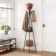 a coat rack with hats and purses on it in front of a white door